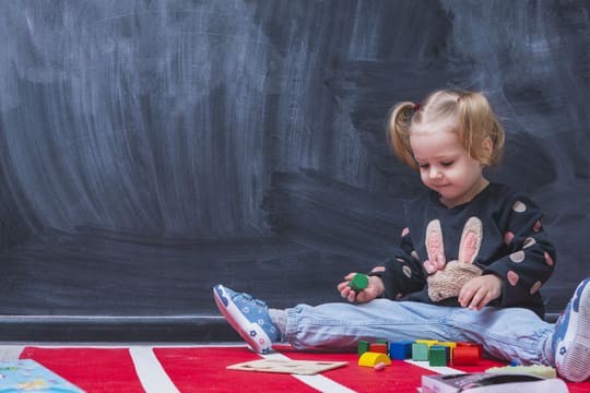 A toddler playing with wooden toys at Nurturing Hearts